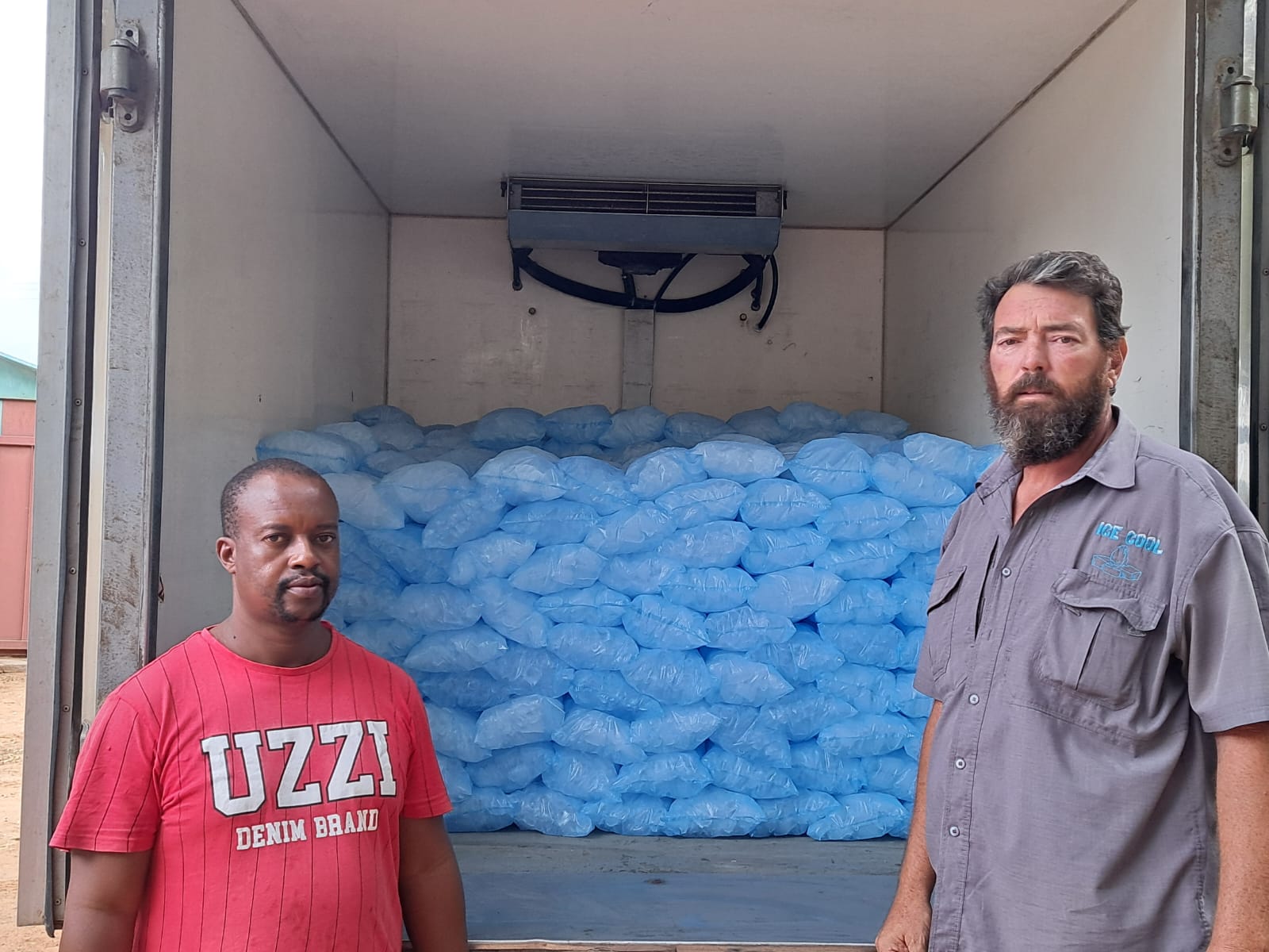Team of Ice Cool workers smiling in front of a delivery van